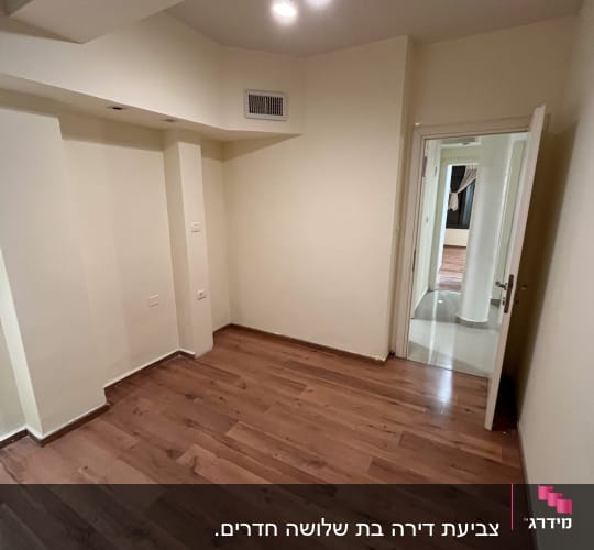 חדר ריק עם רצפת עץ ותאורה